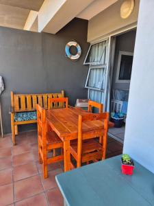 a dining room with a wooden table and chairs at Villa Chanel Sea View in Mossel Bay
