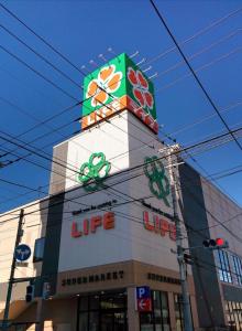 a building with a sign on top of it at 102Room,Free parking just a 7-minute walk from Koiwa tram stop This spacious 75-square-meter flats features two large bedrooms and can accommodate up to seven guests in Tokyo