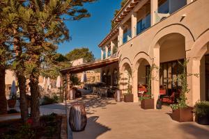 a building with arches and trees and a patio at Purobeach Resort Santa Ponsa - New Opening in Santa Ponsa