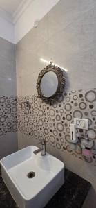 a bathroom with a sink and a mirror on the wall at Hotel Fortune Home Residency Sector 72 in Noida