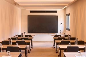 an empty classroom with tables and a large screen at Purobeach Resort Santa Ponsa - New Opening in Santa Ponsa +144 photos