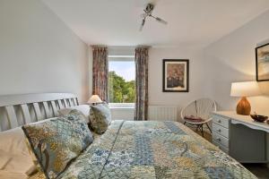 a bedroom with a bed and a desk and a window at Finest Retreats - Riverside View in Balloch