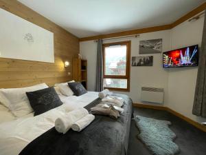 a bedroom with a bed with towels on it at Arc 1950 - Appartement 2 chambres - Ski-in & out - Grande Terrasse Ensoleillée in Arc 1950