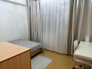 Schlafzimmer mit einem Bett, einem Schreibtisch und Vorhängen in der Unterkunft Enerel tsogtsolbor in Ulaanbaatar