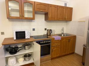 eine Küche mit Holzschränken und einem Herd mit Backofen in der Unterkunft Enerel tsogtsolbor in Ulaanbaatar + 3 Fotos