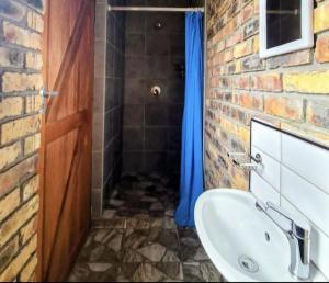 a bathroom with a sink and a brick wall at Malkop Sea View Resort in Lambertʼs Bay