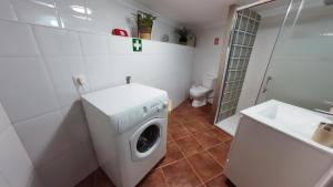 een badkamer met een wasmachine en een wastafel bij 9, Cimo da Aldeia in Aldeia de João Pires +37 foto's