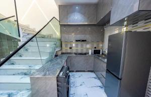 ベニンシティにあるOsaka Apartment by Js Luxuryのキッチン(大理石のカウンタートップ、冷蔵庫付)