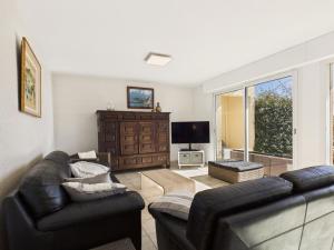 ein Wohnzimmer mit 2 Ledersofas und einem TV in der Unterkunft Face à la mer - Maison pour 8 avec jardin in Port Nayalo