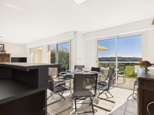 eine Küche und ein Esszimmer mit Tisch und Stühlen in der Unterkunft Face à la mer - Maison pour 8 avec jardin in Port Nayalo