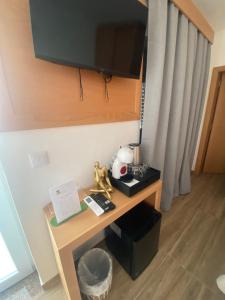 a room with a desk with a television on the wall at Vivenda Por do Sol in Couço