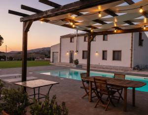 eine Terrasse mit Tisch und Stühlen und einem Pool in der Unterkunft B&B 4 Stagioni in Dattilo