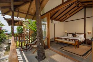 a bedroom with a bed and a tree at The Wave , Palolem in Canacona +11 photos