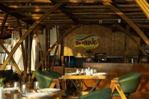 a restaurant with wooden tables and green chairs at The Wave , Palolem in Canacona