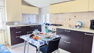 a kitchen with a table with a bowl of fruit on it at Ca’ Marea by Ca-Sa Check in Chioggia