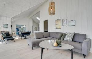 a living room with a couch and a table at Cozy Home In Glesborg With Sauna in Fjellerup