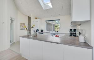 a white kitchen with a counter top and a window at Cozy Home In Glesborg With Sauna in Fjellerup
