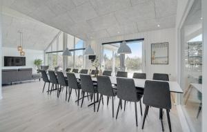 a dining room with a long table and chairs at Cozy Home In Glesborg With Sauna in Fjellerup