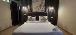 a bedroom with a large bed with white sheets and pillows at Hotel Fortune Home Residency Sector 72 in Noida