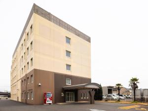 un gran edificio con una gasolinera delante en Comfort Inn Kurashiki Mizushima, en Kurashiki