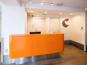 Un mostrador naranja en una habitación vacía con en Comfort Inn Kurashiki Mizushima, en Kurashiki