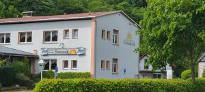 Un edificio blanco con un cartel delante. en Hotel-Gasthof-Sonneneck, en Schalkau 2 fotos más