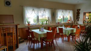 un restaurante con 2 mesas, sillas y ventanas en Hotel-Gasthof-Sonneneck, en Schalkau