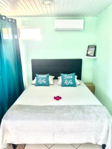 Un dormitorio con una cama con una flor roja. en Manahiti properties, en Moorea