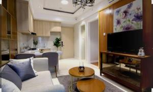 a living room with a white couch and a television at Friendly Bersama Villa in Medan