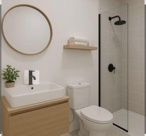 a bathroom with a toilet and a sink and a mirror at Friendly Bersama Villa in Medan