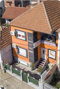 een oranje huis met een bord erop bij Vila Mala Evropa in Leskovac