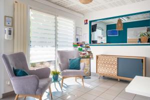 a living room with two chairs and a television at Comfort Aparthotel Nantes La Beaujoire in Nantes