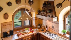 une cuisine avec un évier et un comptoir avec des casseroles et des poêles dans l'établissement LE MACINE 6, Emma Villas, à Castel del Piano