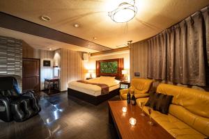 a hotel room with a bed and a couch at ホテルミント羽島 in Hashima