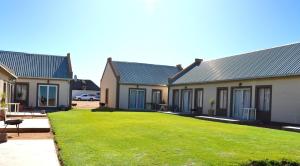 una hilera de casas con césped delante de ellas en Grünau Chalets, en Khomas Region 18 fotos más