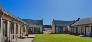 una hilera de casas con césped en el medio en Grünau Chalets, en Khomas Region