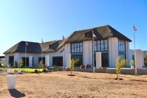 Un gran edificio con banderas en el frente. en Grünau Chalets, en Khomas Region