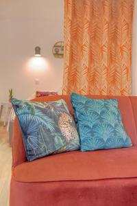 a couch with two blue pillows on it at Le Morgon, Studio Confort, proximité Villefranche Centre in Gleizé