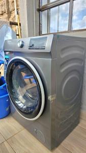 lavadora en la parte superior de un suelo de madera en Hosted by Shee -One bedroom Ruaka near Two Rivers, en Ruaka