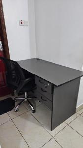 Un escritorio negro con una silla negra y un escritorio para computadora en Hosted by Shee -One bedroom Ruaka near Two Rivers, en Ruaka