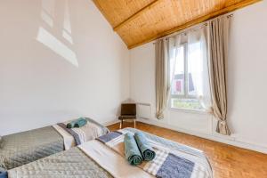 two beds in a room with a window at La Grande Maison Paris Sud in Vitry-sur-Seine +93 photos
