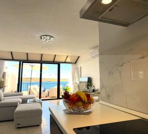 a kitchen with a bowl of fruit on a counter at Seafront apartment 2 bedrooms Terrace & Panoramic ocean views in Is-Sellum +16 photos