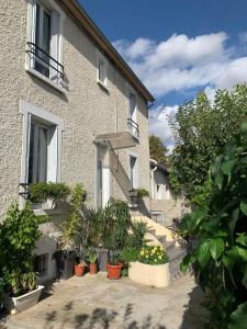 a building with potted plants on the side of it at La Grande Maison Paris Sud in Vitry-sur-Seine