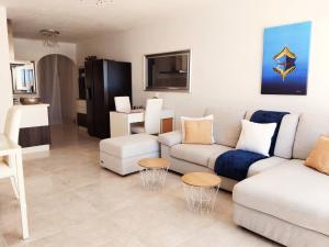 a living room with a couch and a tv at Seafront apartment 2 bedrooms Terrace & Panoramic ocean views in Is-Sellum