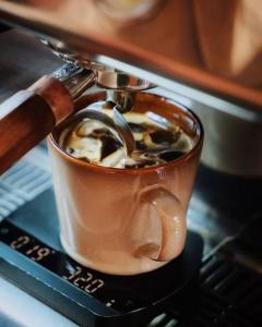 a cup of coffee is being brewed in a coffeemachine at Meriton M Hotel The interior features a terrace offers laundry services Free coffee travel services and dining recommendations It is close to Sanlitun, a vibrant area for young people, and near the subway station, making it convenient to reach any attra in Beijing