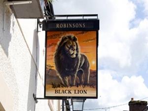 Llanfair TalhaiarnにあるThe Black Lionの建物の側面にある黒いライオンの看板