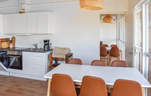 a kitchen and dining room with a white table and chairs at 5 Bedroom Amazing Home In Hanstholm in Pugdal