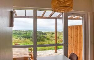 a kitchen with a view of the ocean through a glass door at 5 Bedroom Amazing Home In Hanstholm in Pugdal
