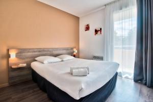 Ένα ή περισσότερα κρεβάτια σε δωμάτιο στο Comfort Aparthotel Toulouse Métropole +33 φωτογραφίες