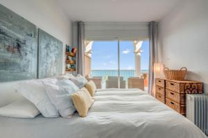 a bedroom with a bed with a view of the ocean at Jávea Beachfront Penthouse in Platja de l'Arenal +19 photos